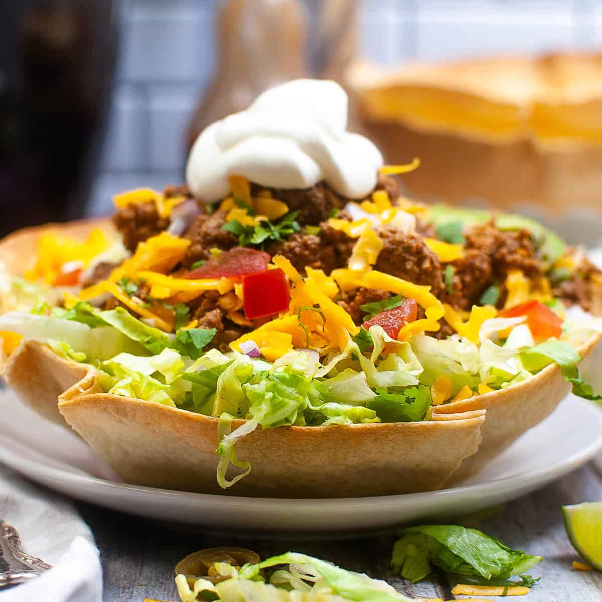 taco salad in a tortilla bowl on a white plate