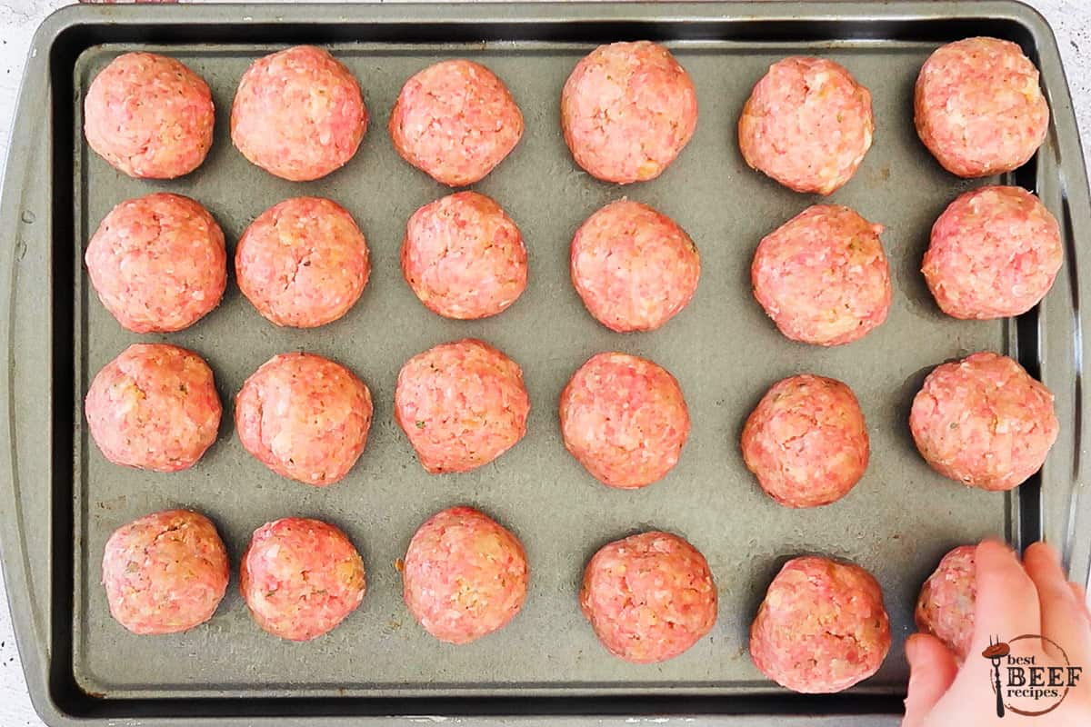 italian meatballs rolled on a baking sheet