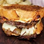 close up of pot roast sandwich with melty cheese, caramelized onions and tender pot roast
