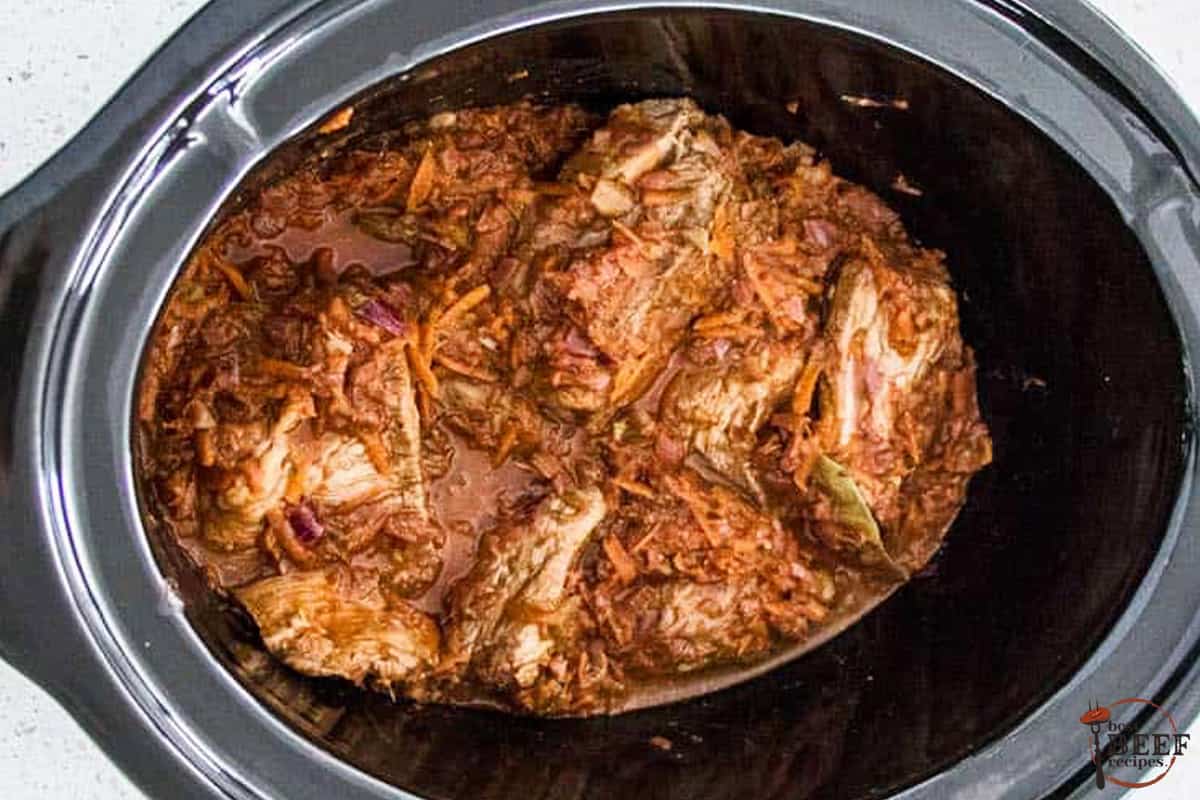 adding beef into slow cooker