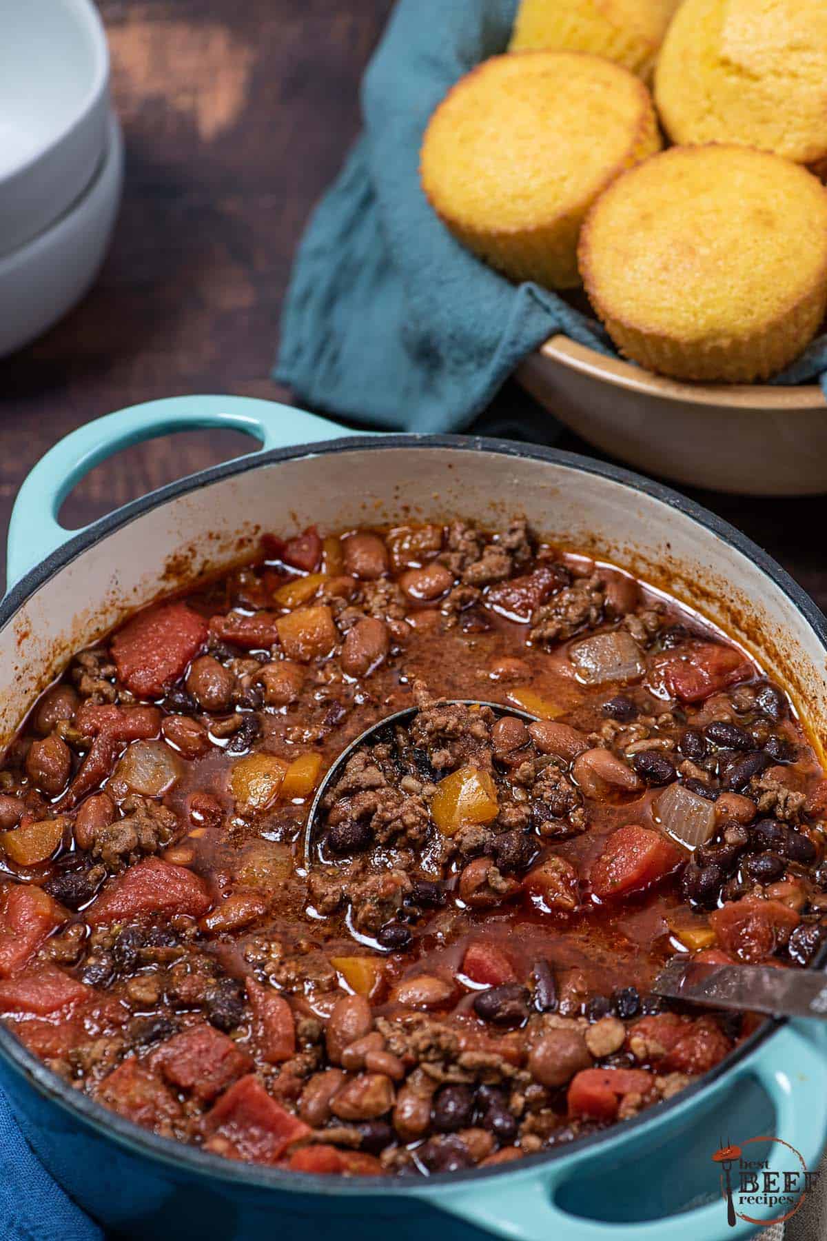 big pot of beef chili next to a pan of cornbread