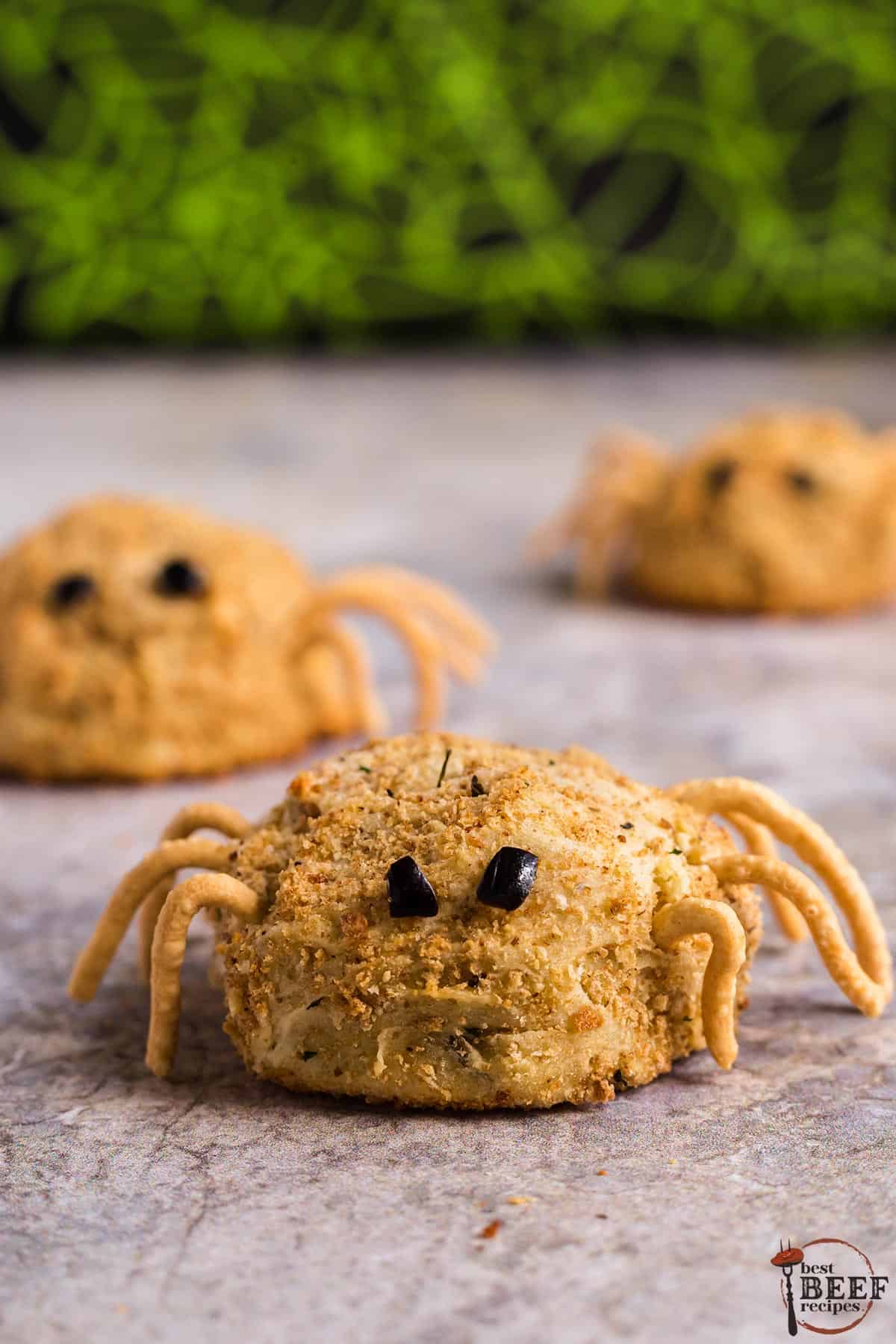 three papas rellenas with chow mein legs and olive slices to look like spiders