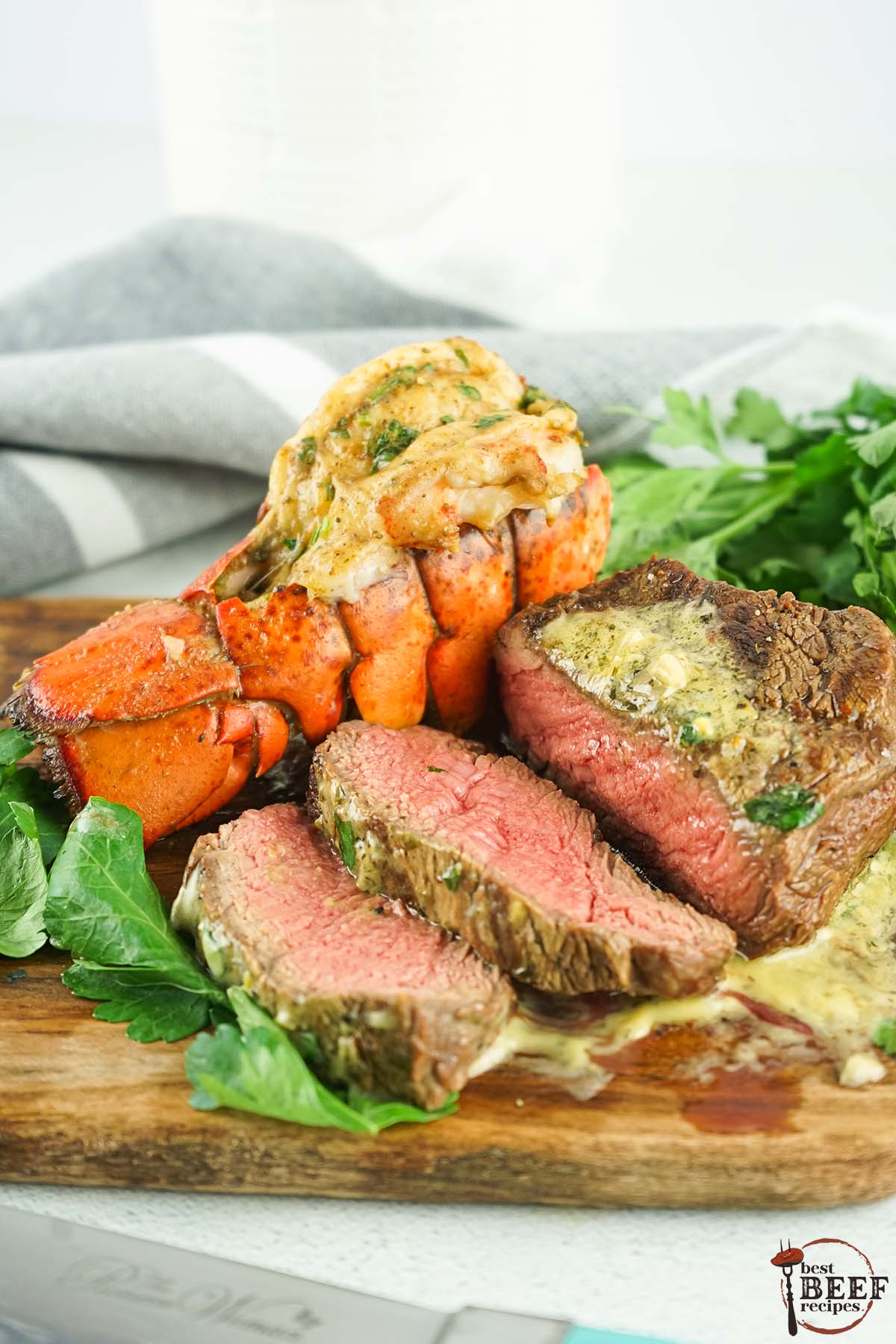 sliced grilled filet mignon next to lobster tail with bearnaise sauce