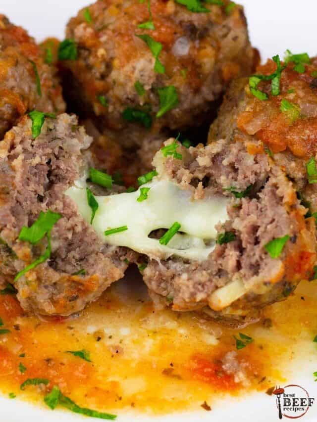a white plate full of mozzarella stuffed meatballs with the front meatball split to show the melted cheese inside
