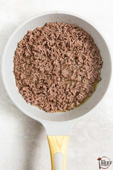 browned ground beef in a frying pan on a counter
