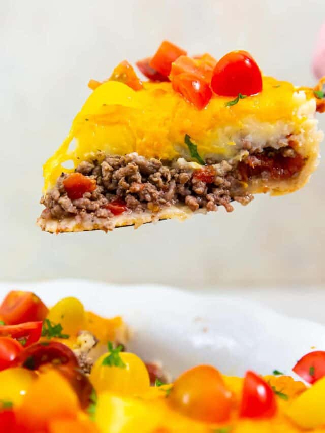 a slice of cheeseburger pie being lifted out of a pie dish with a pie slicer