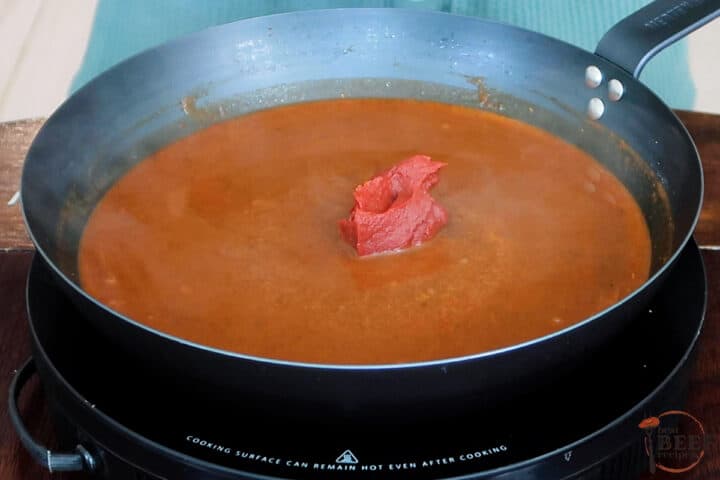 tomato paste in enchilada sauce in a skillet