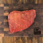 london broil steak on cutting board after marinating