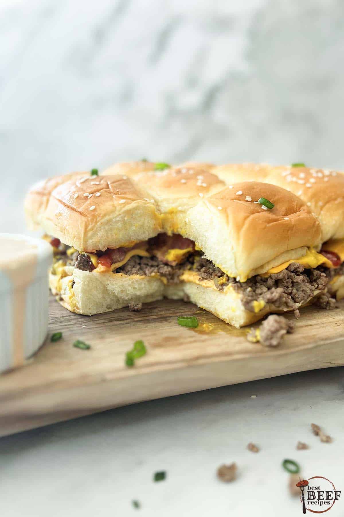 cheeseburger sliders with bacon on a serving board