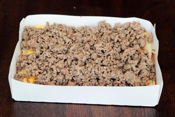 Adding cooked ground beef to slider rolls in package