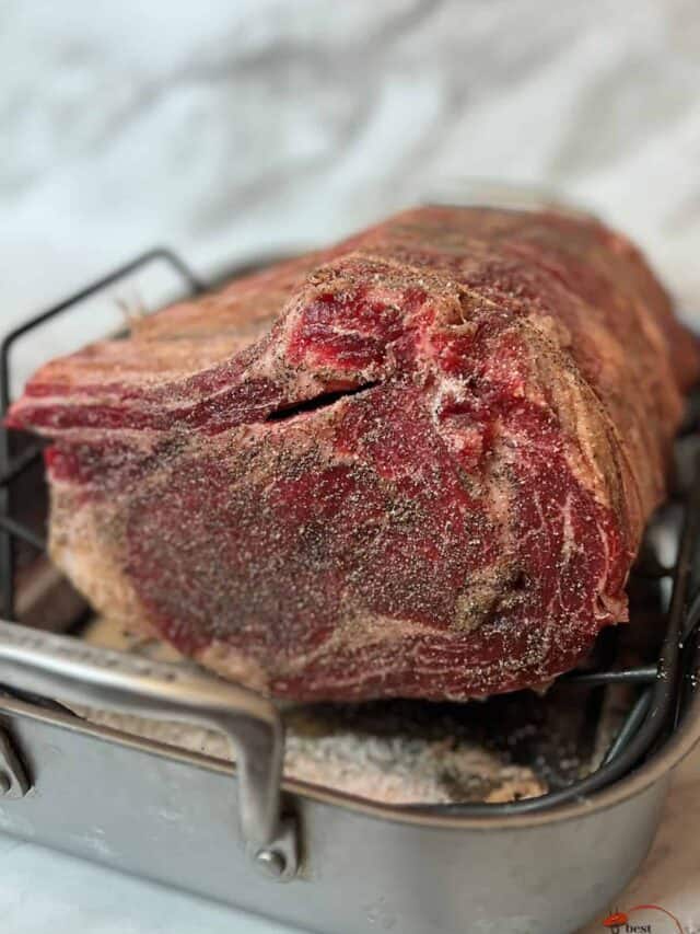 seasoned dry aged prime rib on a roasting rack and pan