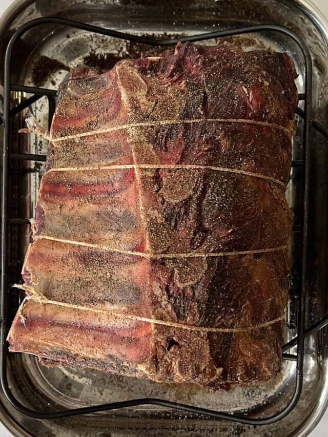 a darkened, visibly drier dry aged prime rib on a rack