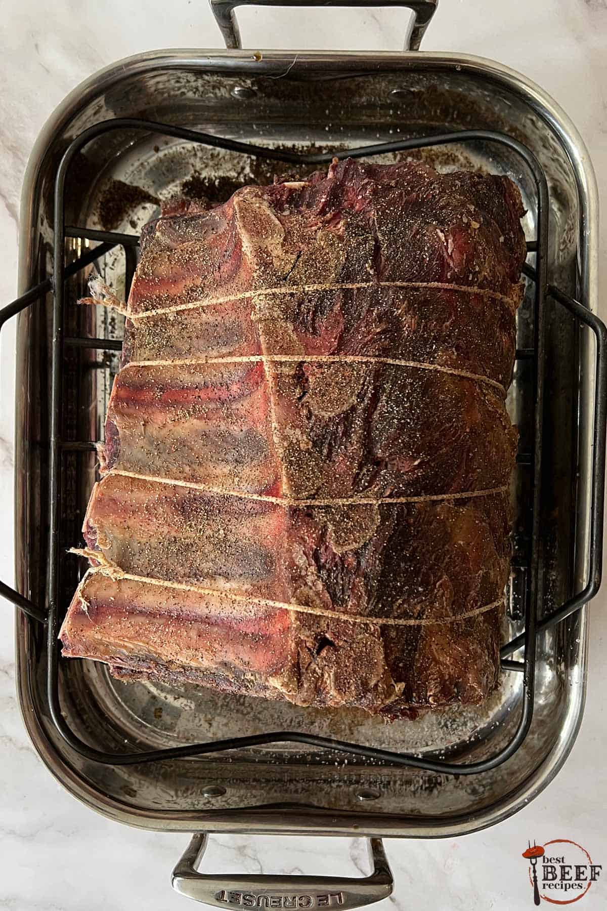 a darkened, visibly drier dry aged prime rib on a rack