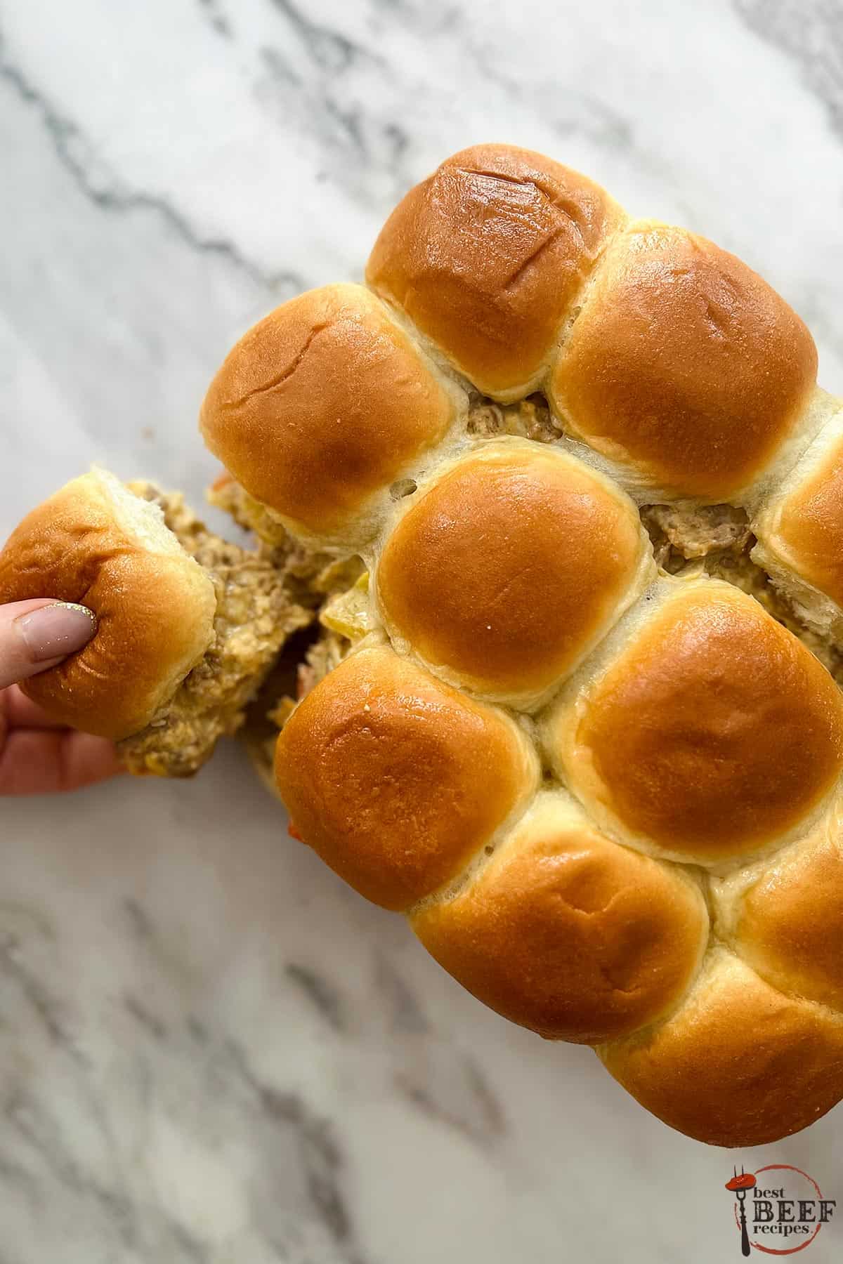 Philly cheesesteak sliders on a white board