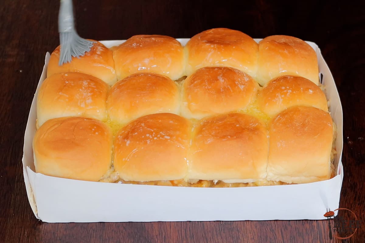 adding butter to the buns on philly cheesesteak sliders
