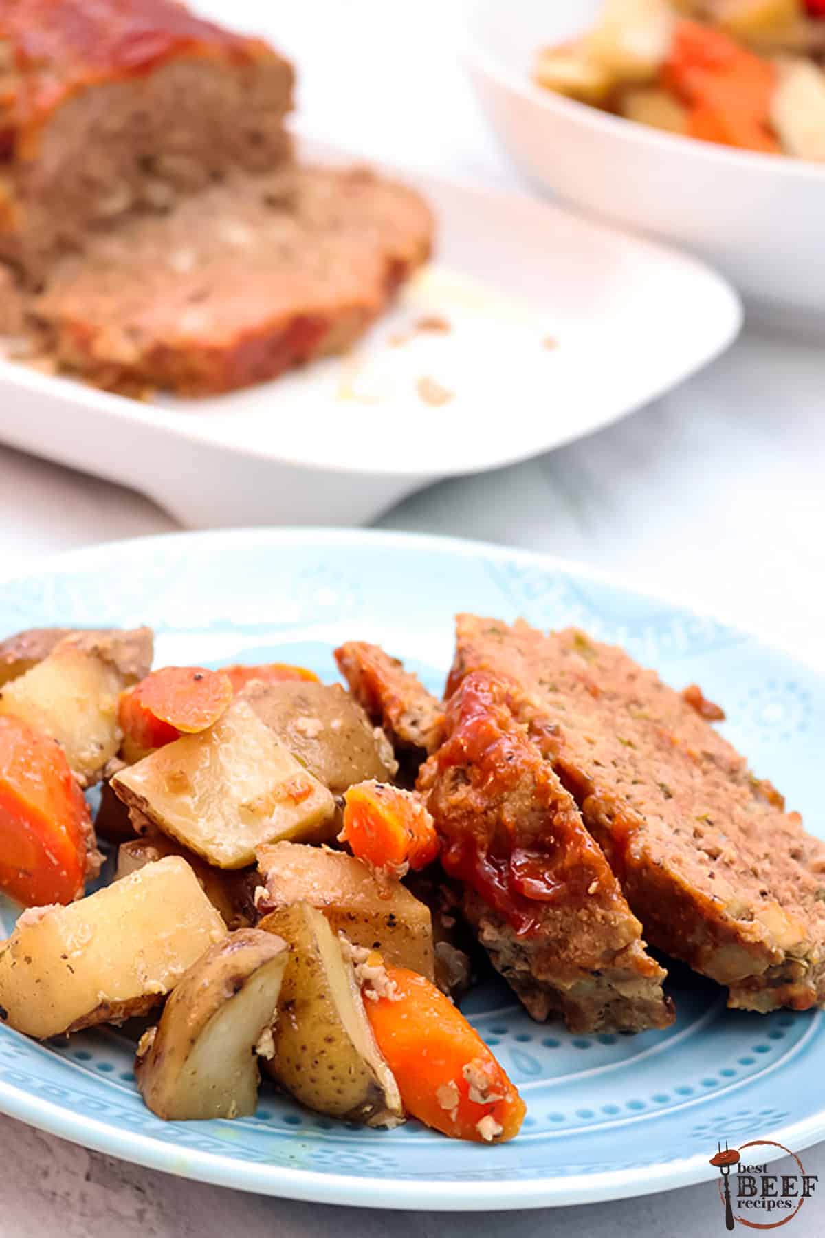 carrots, potatoes, and slow cooker meatloaf on a plate with meatloaf in the background