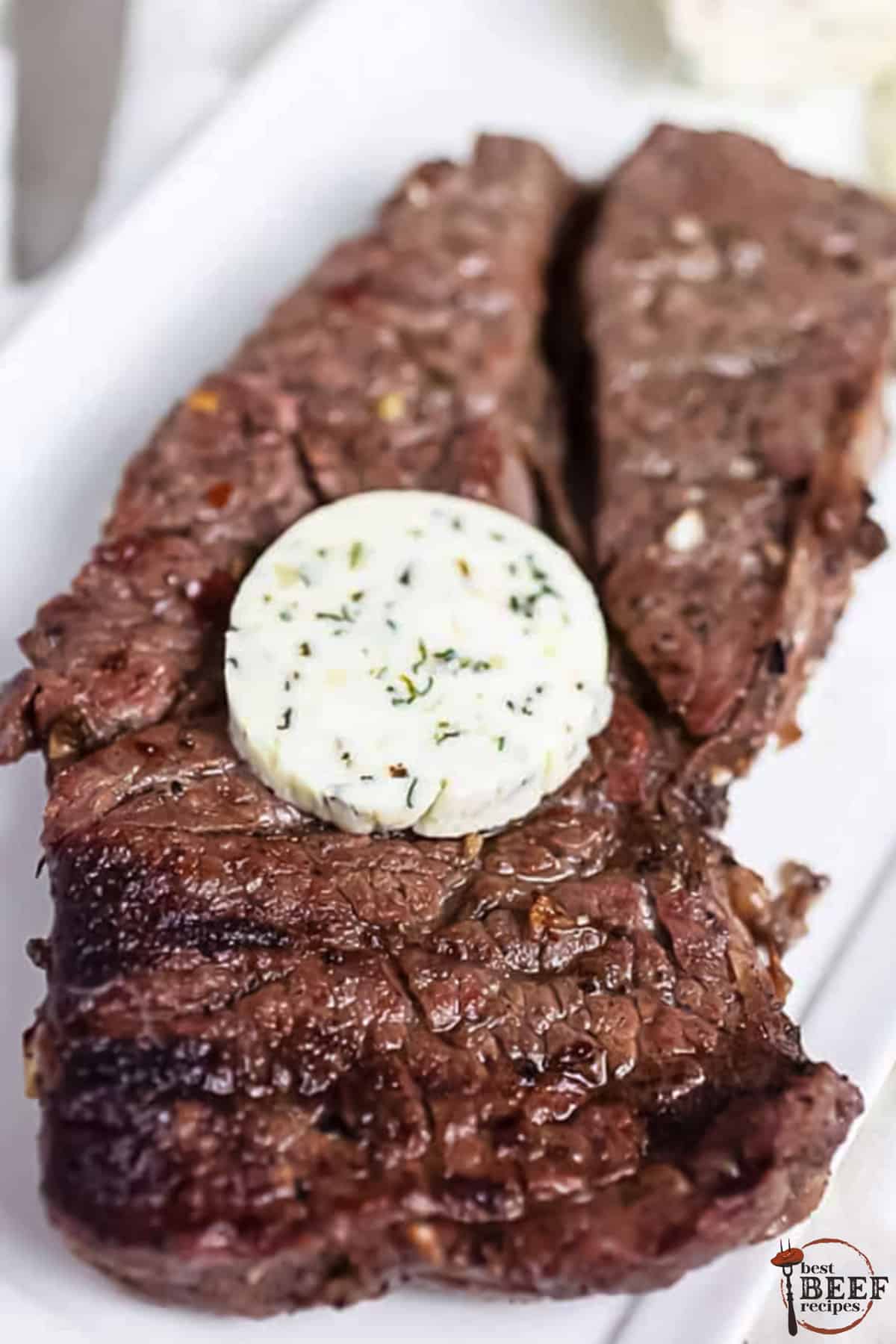 a seared marinated steak with a slab of herb butter