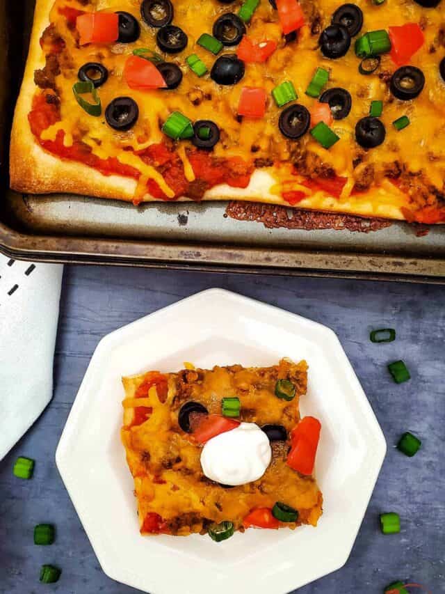 taco pizza in a pan next to a plate with a slice of taco pizza