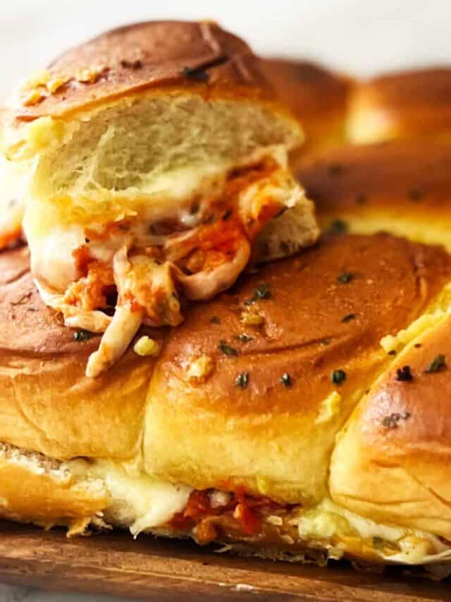a stack of meatball sliders showing off cheese pulls and sauce