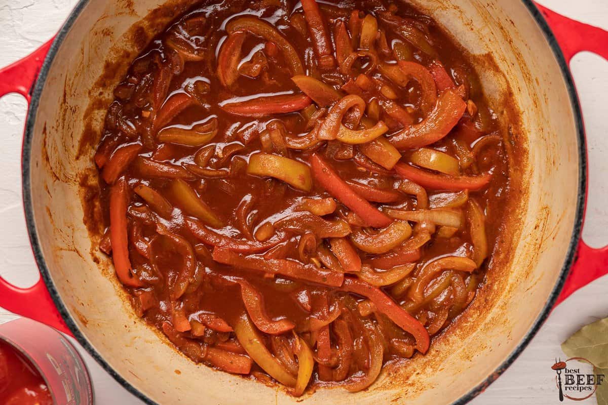 the tomato paste and seasonings added to the pot and mixed
