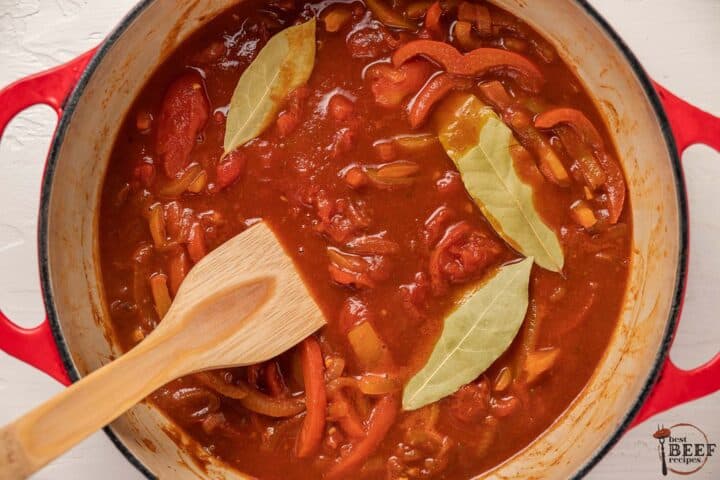 ropa vieja vegetables and broth in a pot with bay leaves