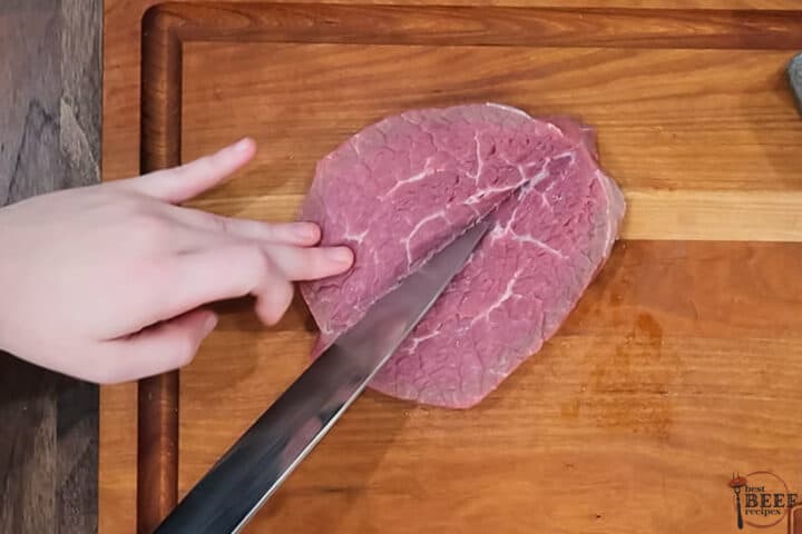 steak being butterflied on a cutting board