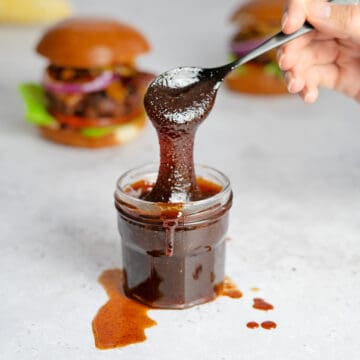 spoonful of bbq sauce over a jar of sauce