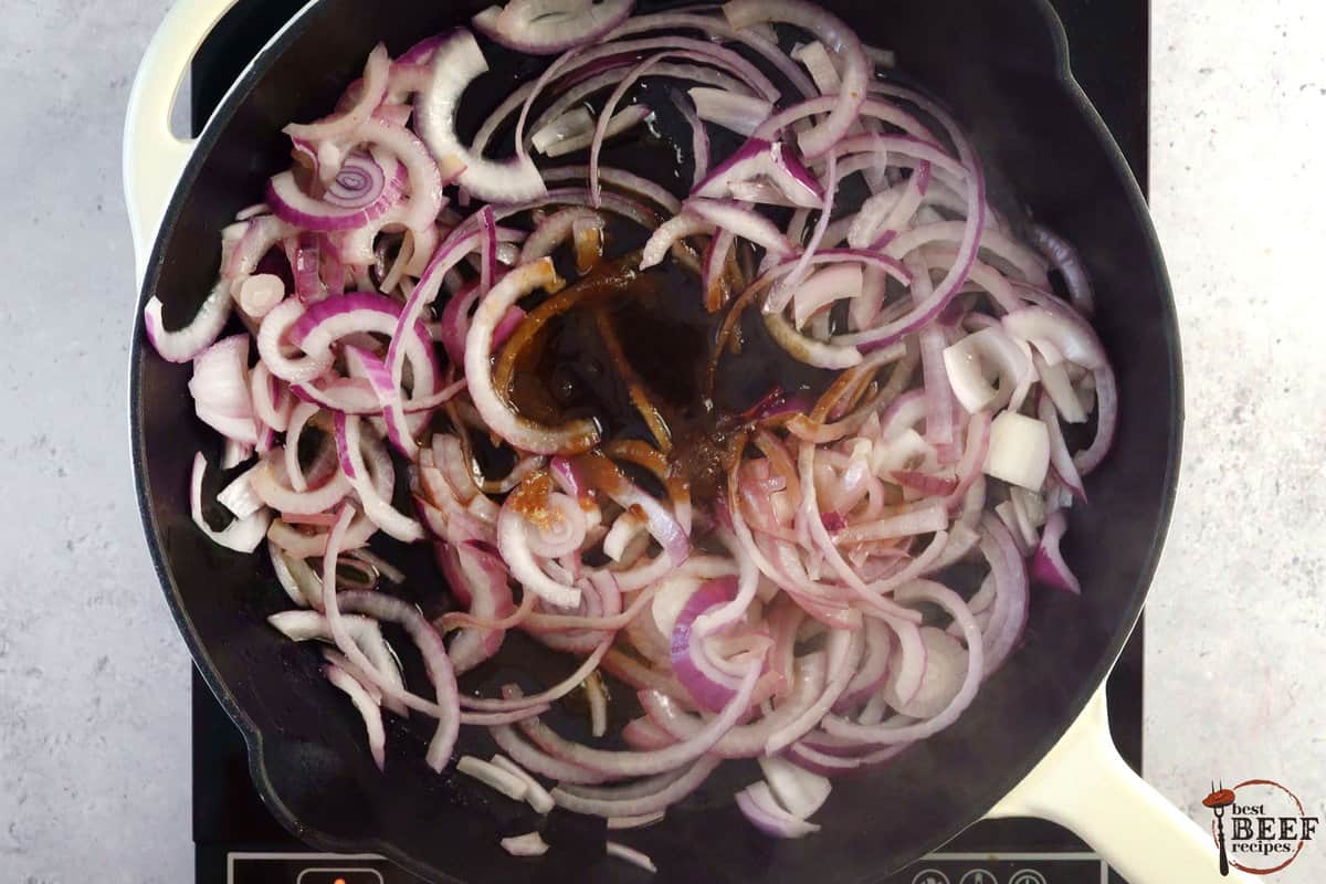 adding ingredients for caramelized onions to onions and butter in a skillet