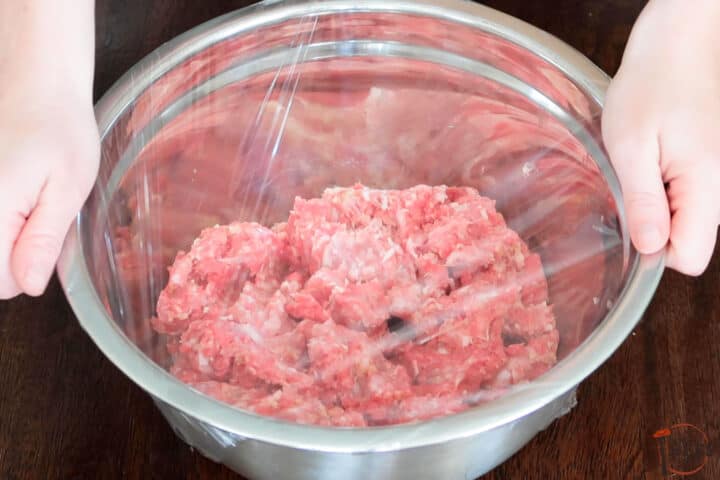 plastic wrap placed over the meatball mixture