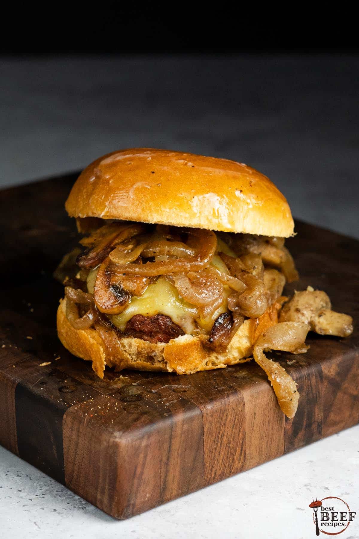 singular mushroom Swiss burger sitting on a wood cutting board