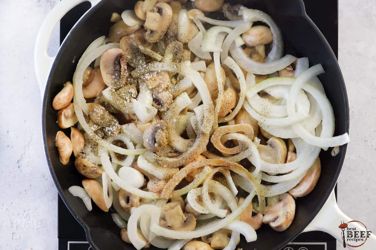sliced onions and seasoning in a skillet