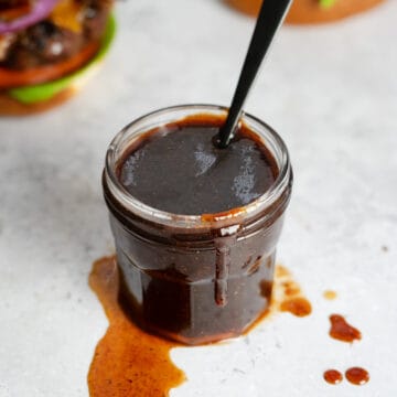 bbq sauce in a clear jar with a spoon inside