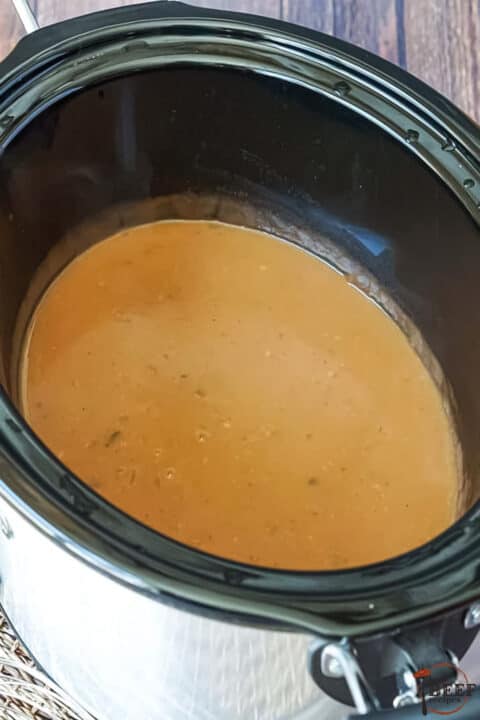 a slow cooker filled with beef gravy