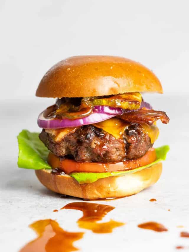 bbq burger with dripping bbq sauce on a white surface