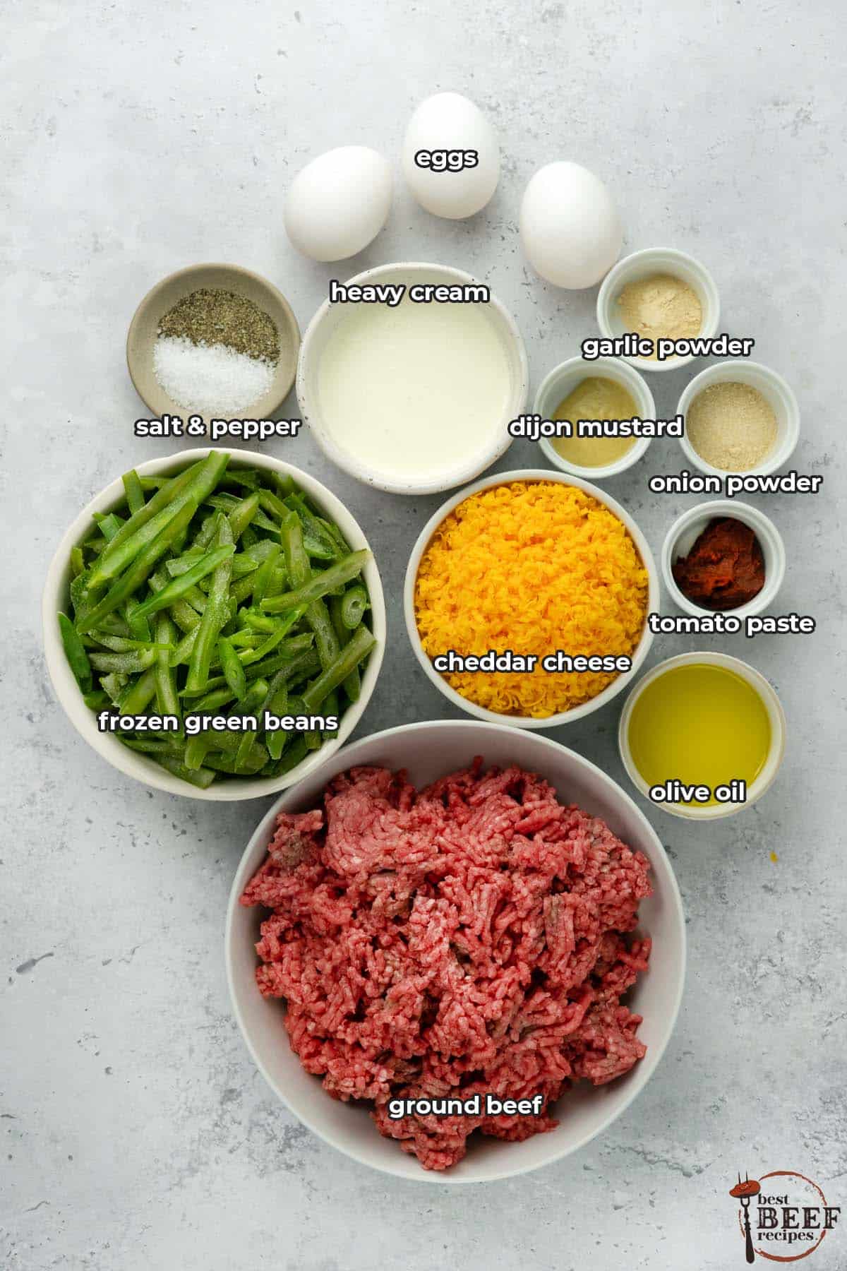 ingredients to make hamburger casserole on a white surface with labels