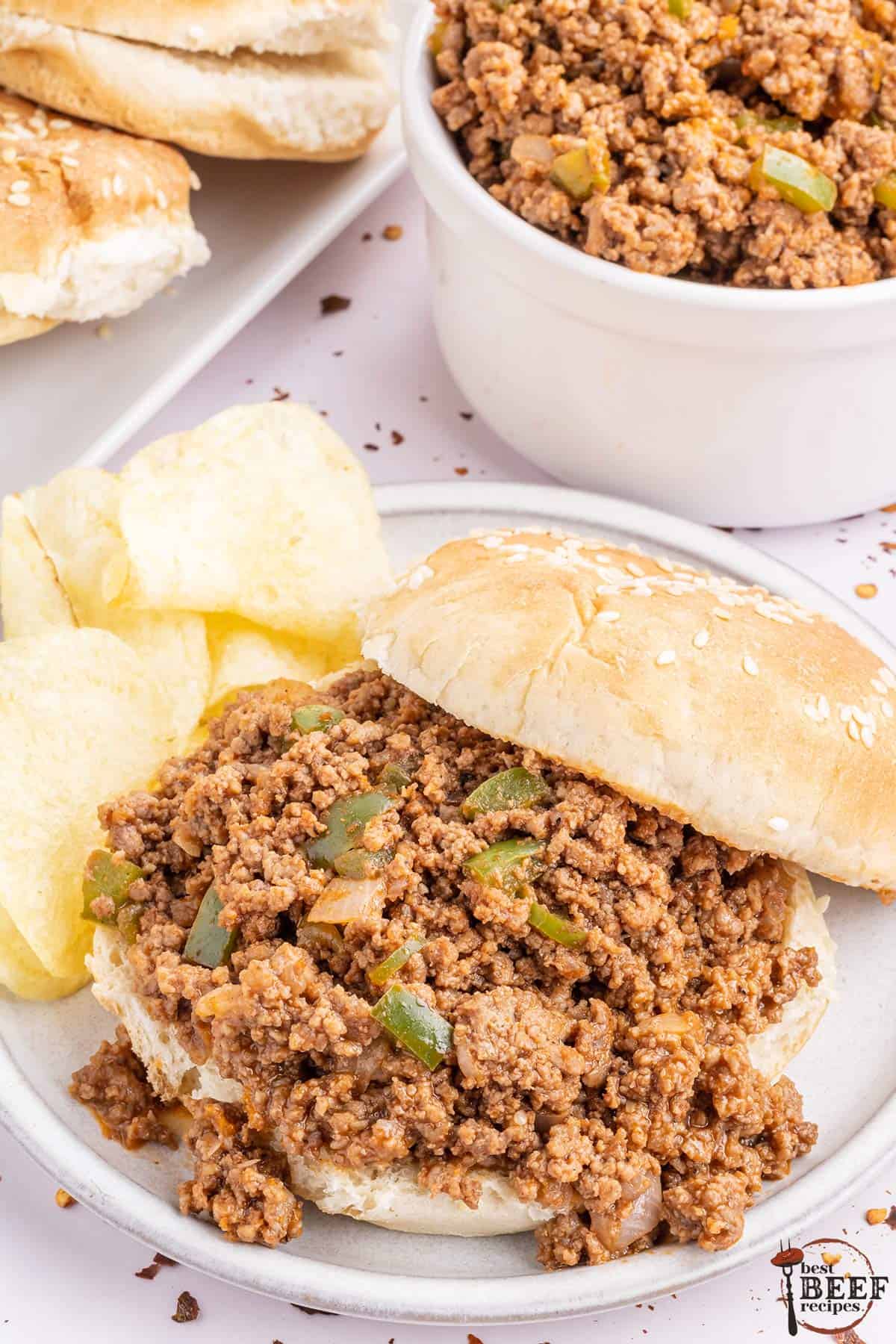 a sesame bun topped with sloppy joe mix with chips