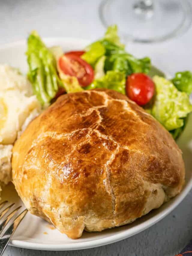 a dinner plate complete with beef wellington, mashed potatoes, and a salad