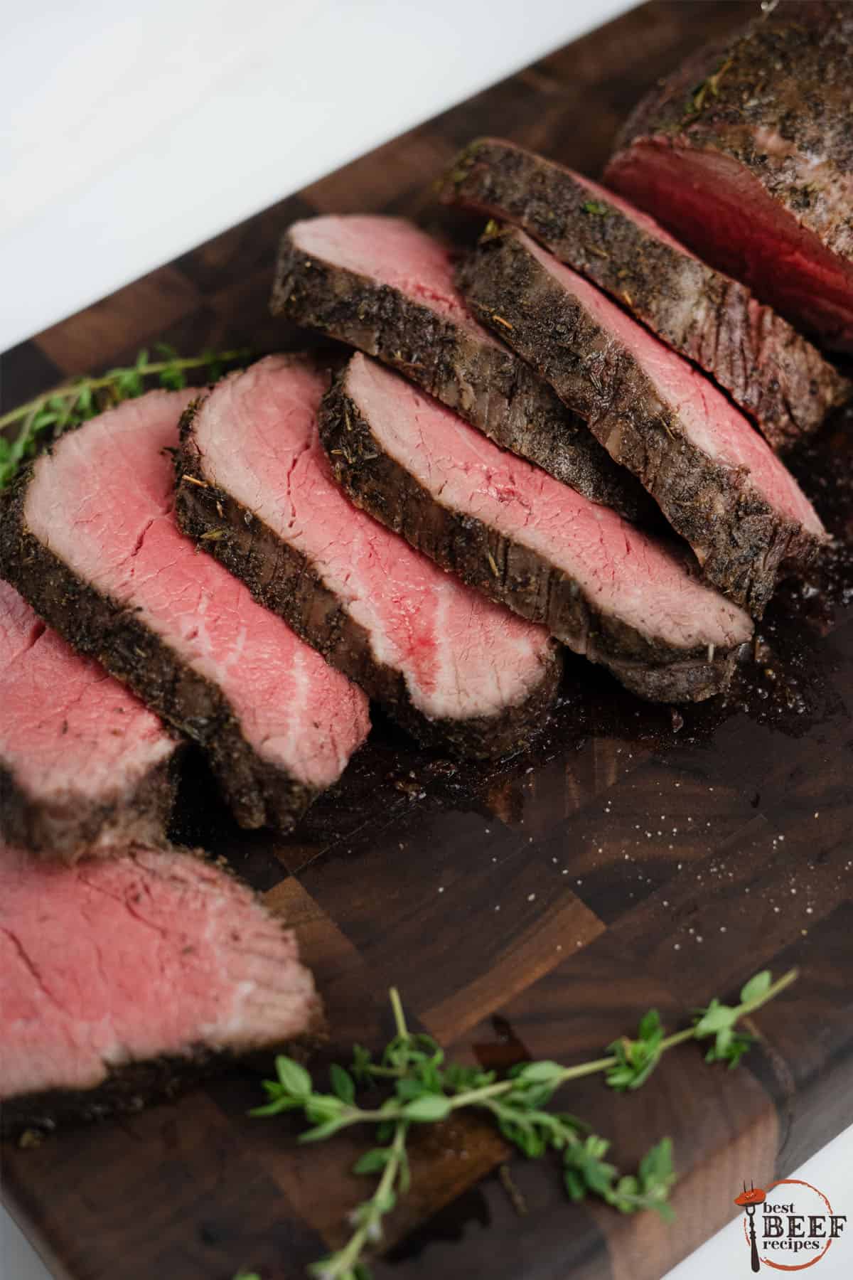 sliced beef tenderloin on a wood cutting board