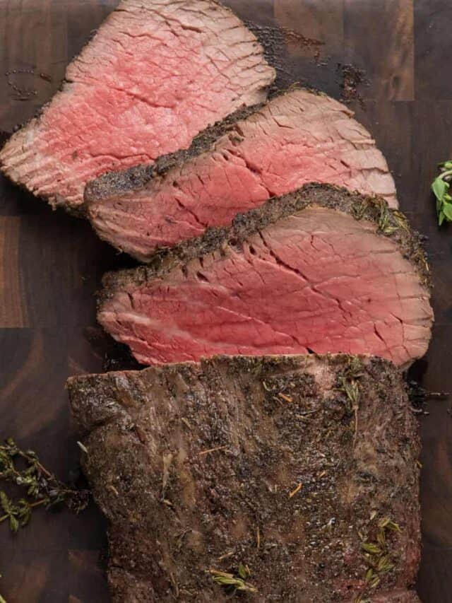 sliced beef tenderloin on a wood cutting board