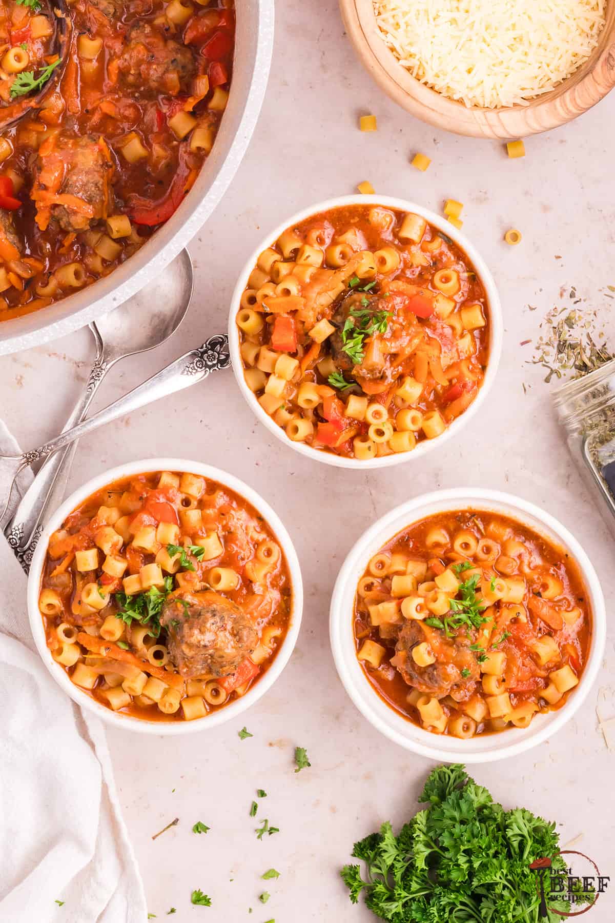 Three bowls of Italian soup with meatballs topped with Parsley