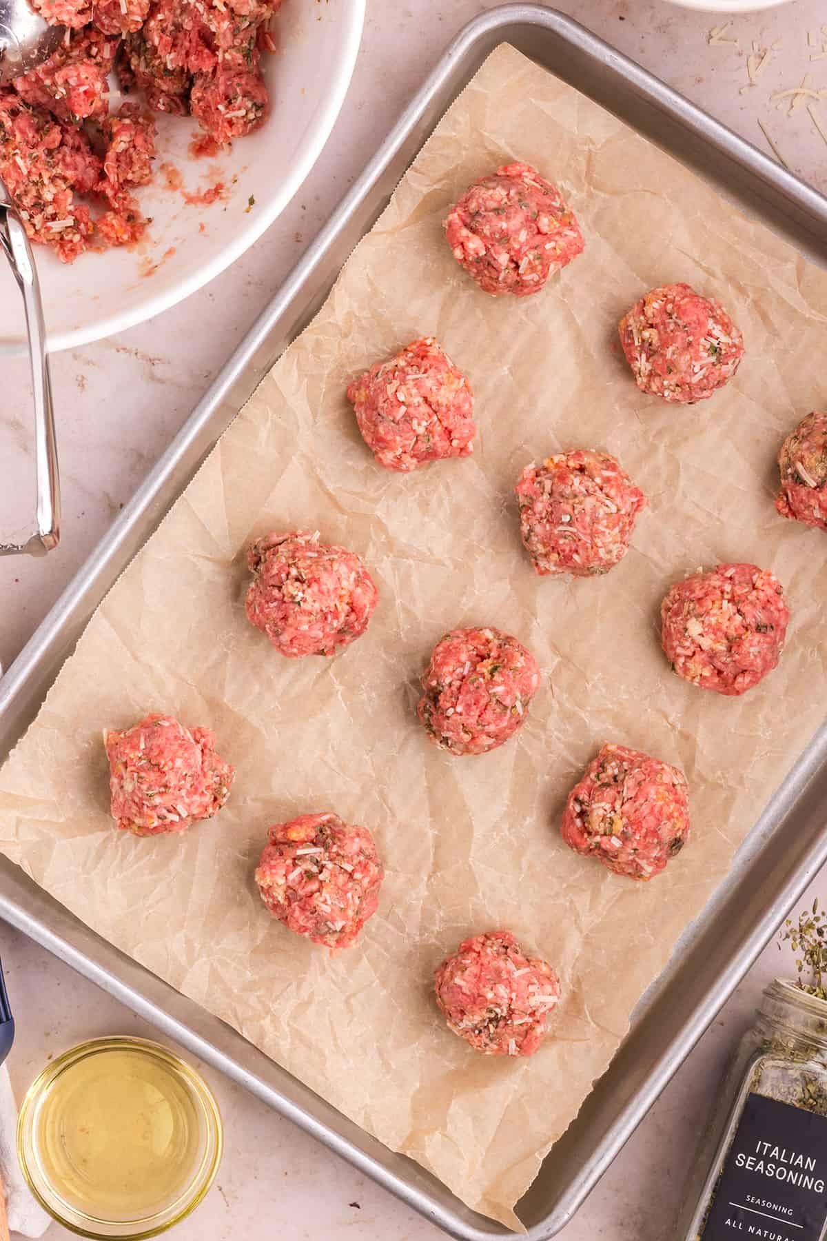 meatballs rolled and placed on a parchment-lined baking sheet