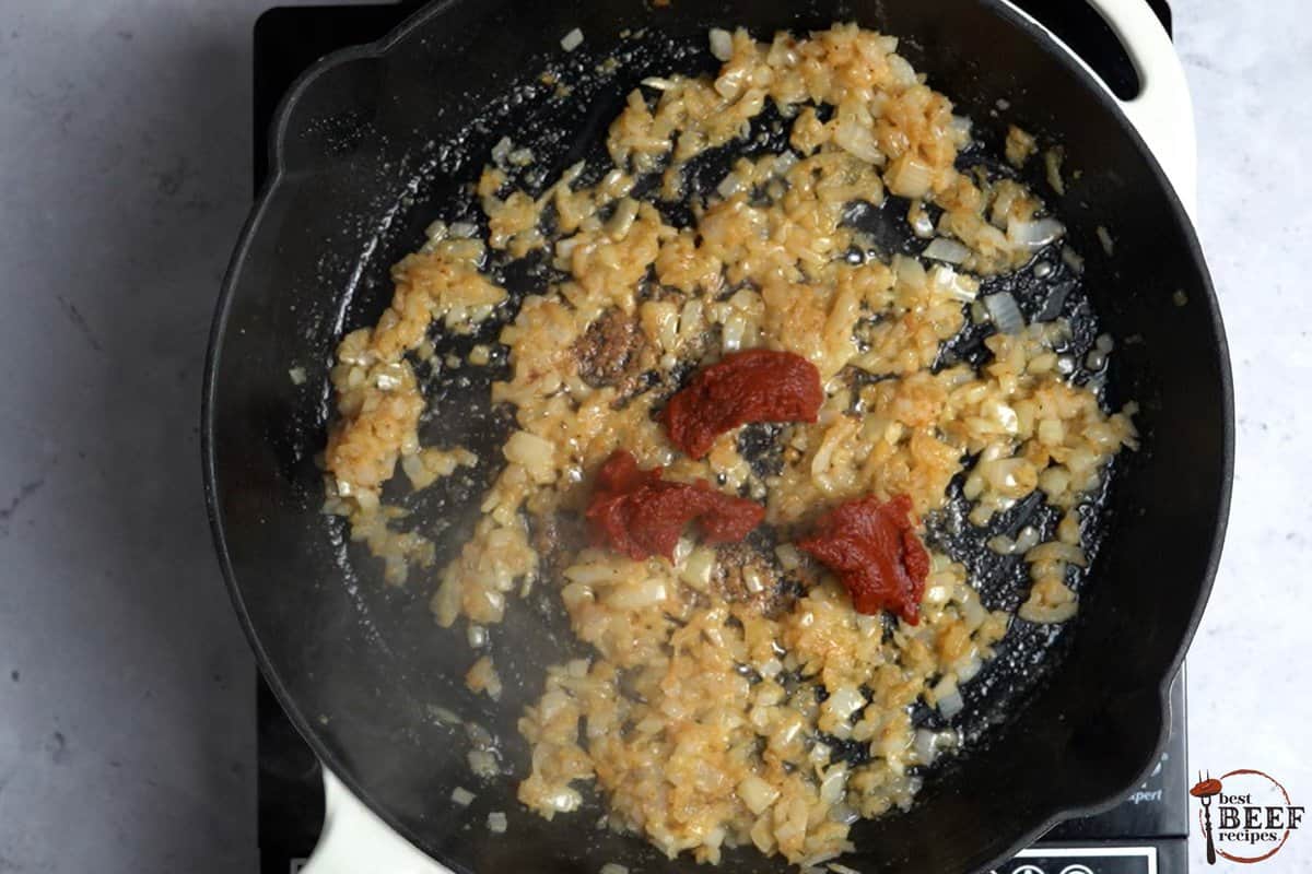 onions in skillet with tomato paste