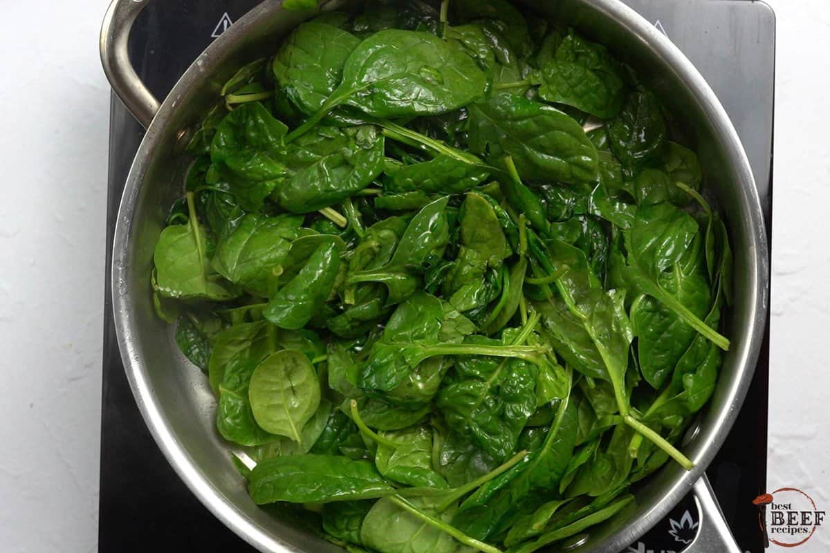 the spinach added to the pan to wilt