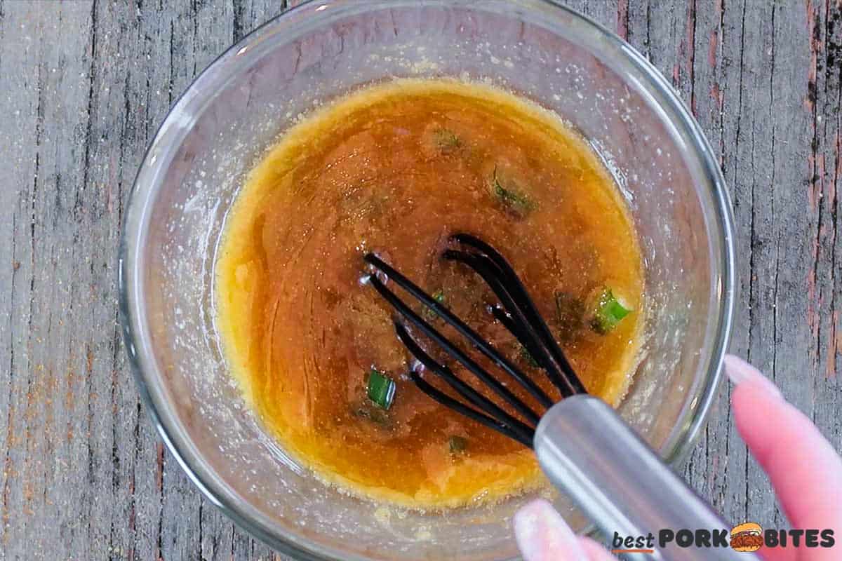 mixing air fryer ham garlic butter in a bowl with a whisk