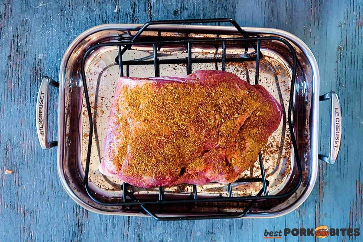 Seasoned pork butt in a roasting pan