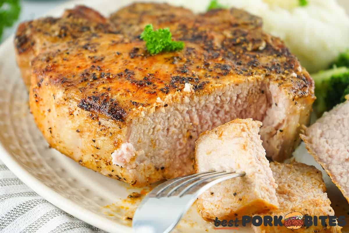 sliced grilled pork chop on a plate with a fork