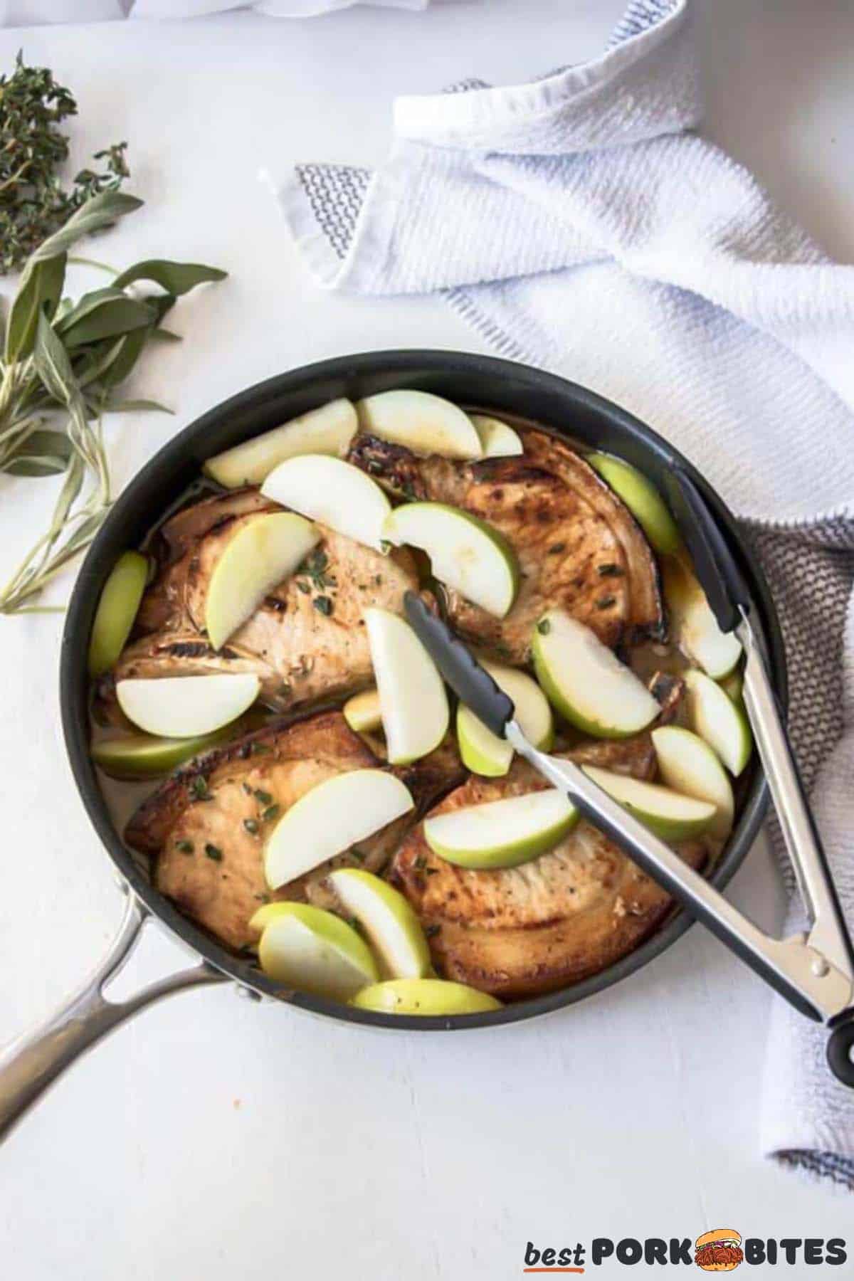 pork chops cooking with apples in pan