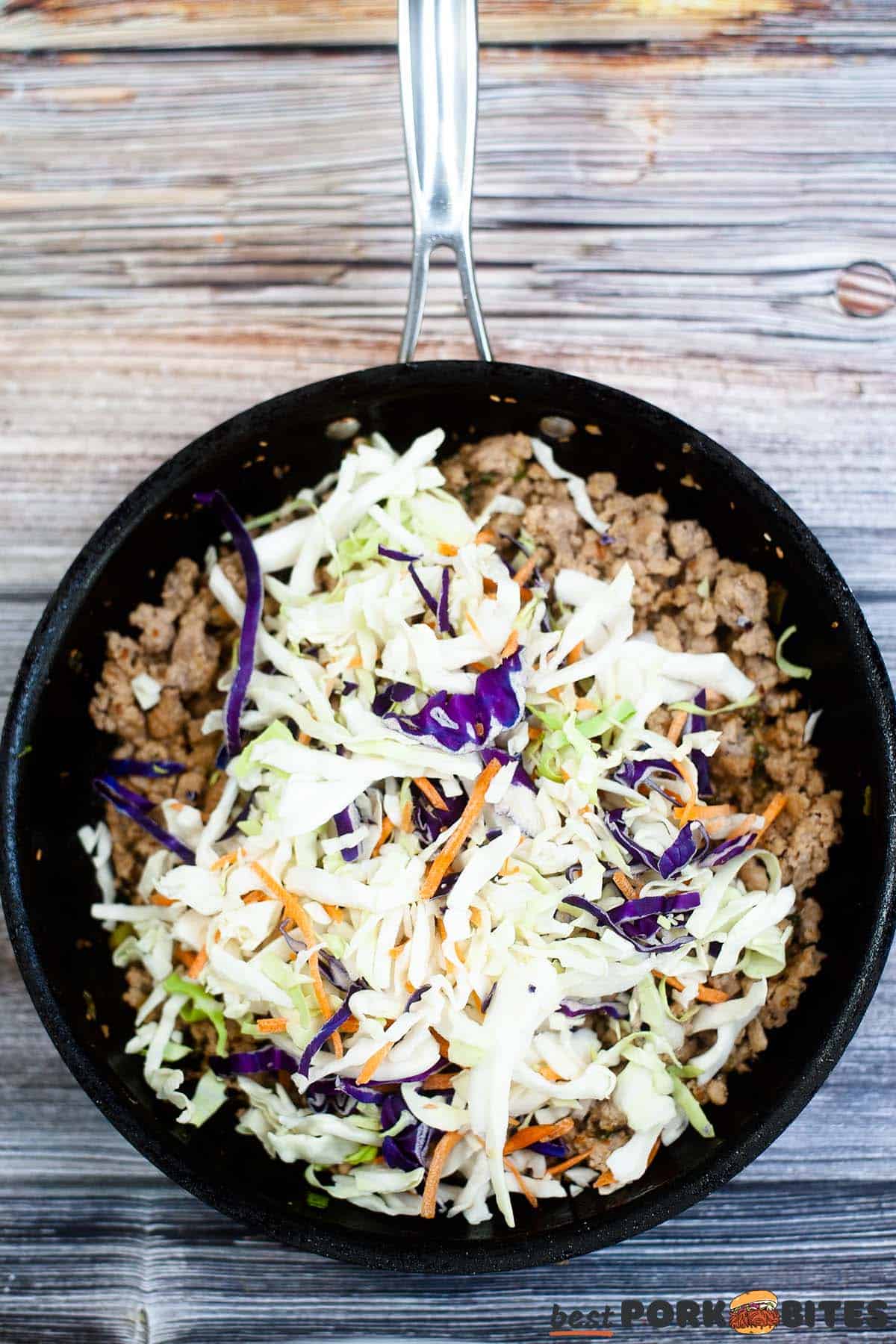 adding slaw to pork in a pan