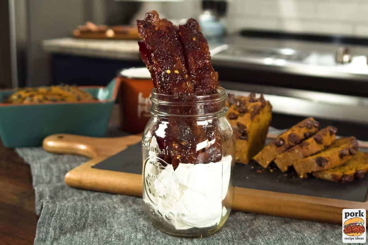 candied bacon in a glass jar next to baked goods