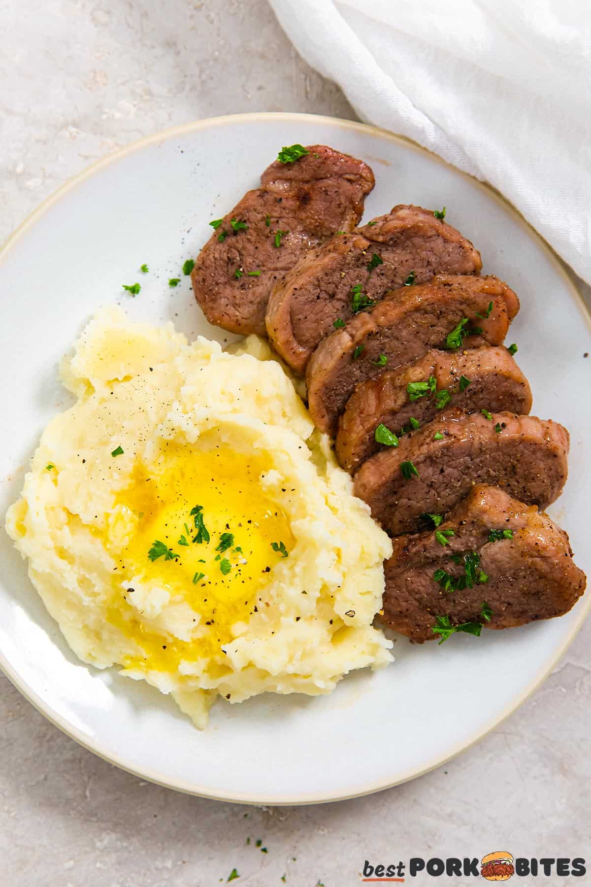a top down image of a plate with mashed potatoes and pork tenderloin
